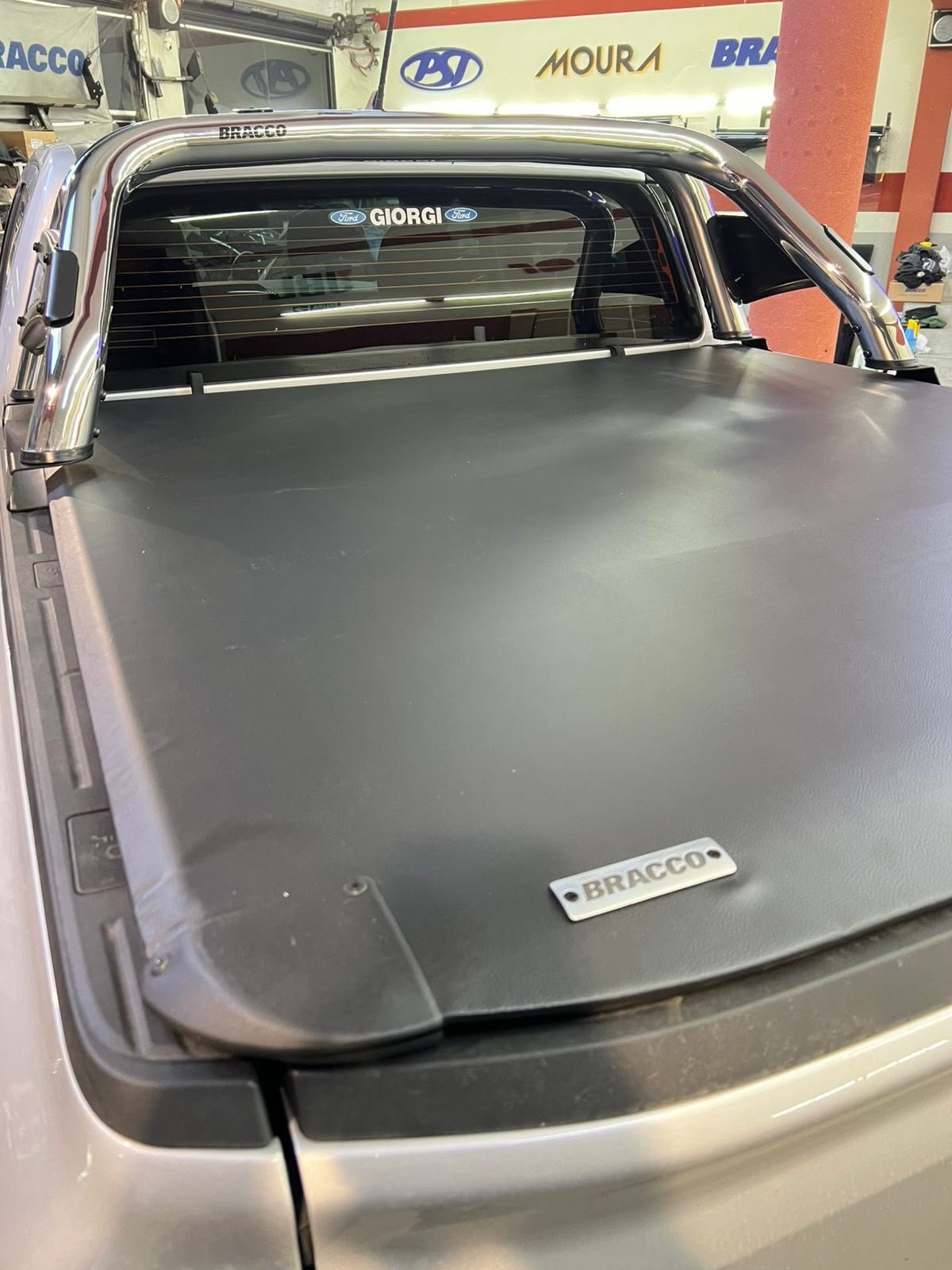 Tapa BRACCO cerrada junto a jaula instalada en la caja de una pickup