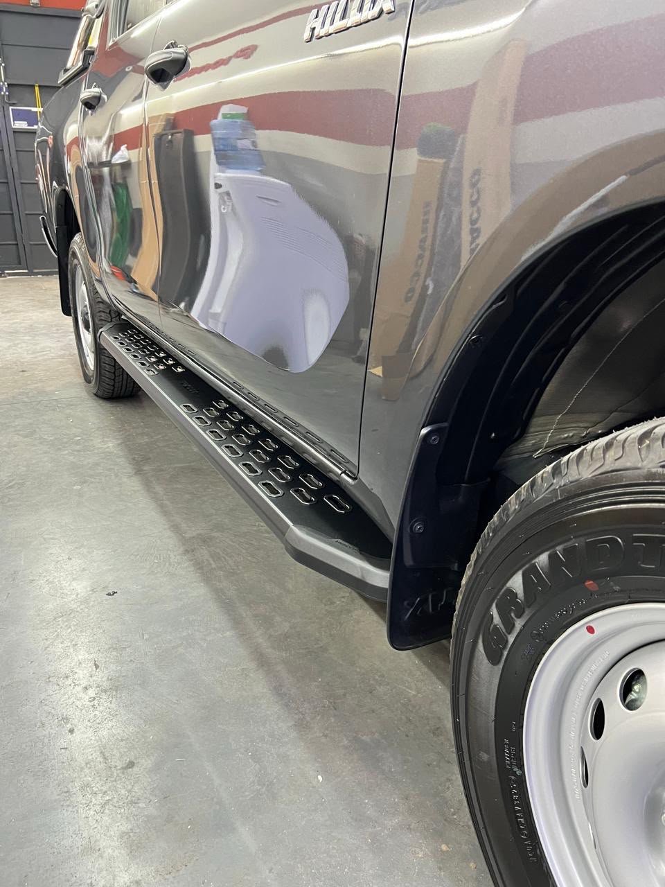 Detalle del estribo negro BRACCO instalado en Toyota Hilux